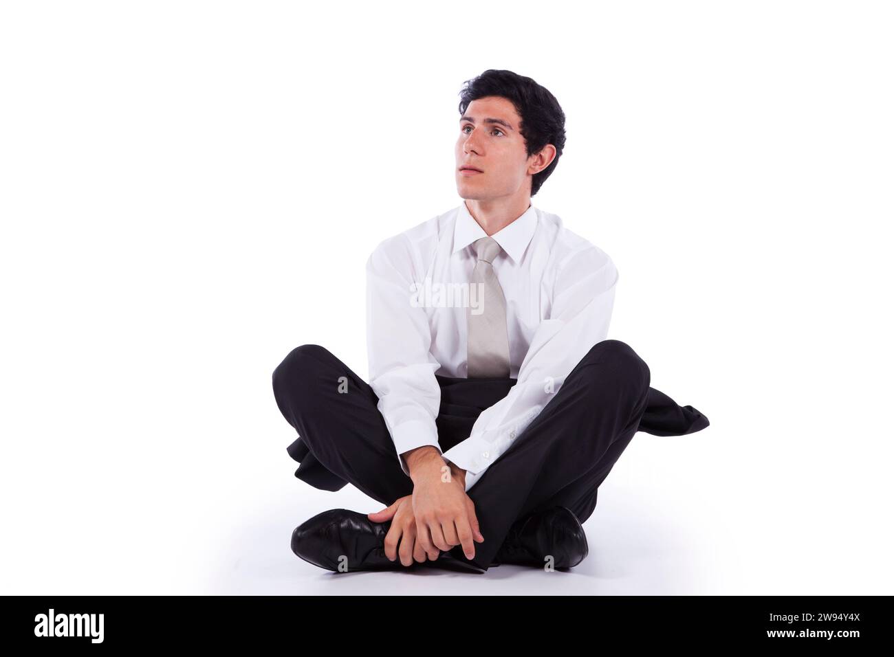 Young and modern businessman relaxing on the floor (isolated on white) Stock Photo