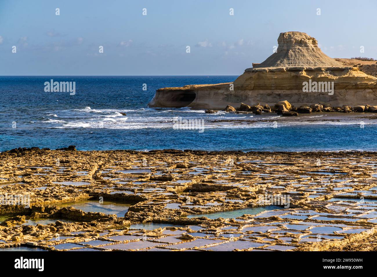 Salt pans of the Cini family in Xwejni Bay, in the background the White HIll, a bizarre rock formation of limestone sandstone. The family has been operating the salt pans in the north of Gozo since 1860. Leli Tal-Melh Salt Shop in Xwejni near Marsalforn, Gozo, Malta Stock Photo