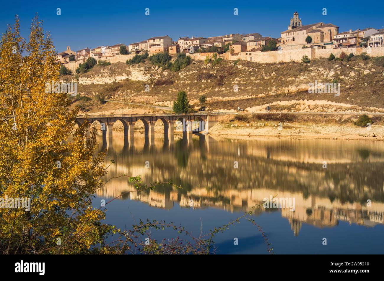 View of Maderuelo reflected on the water of Linares reservoir Stock Photo