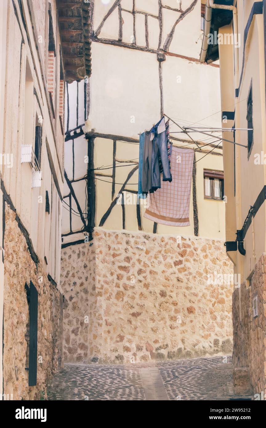 A quiet corner of Poza de la Sal with traditional timber-framed buildings and hanging clothes (Spain) Stock Photo