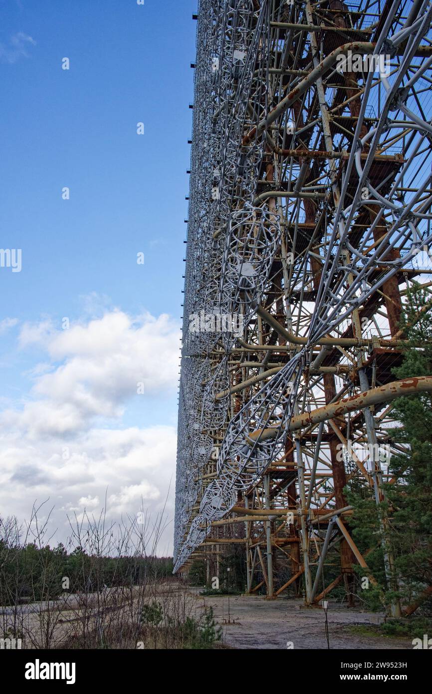 A large metal structure stands amidst a barren landscape, its intricate design contrasting the sky. Duga is a Soviet over-the-horizon radar station fo Stock Photo