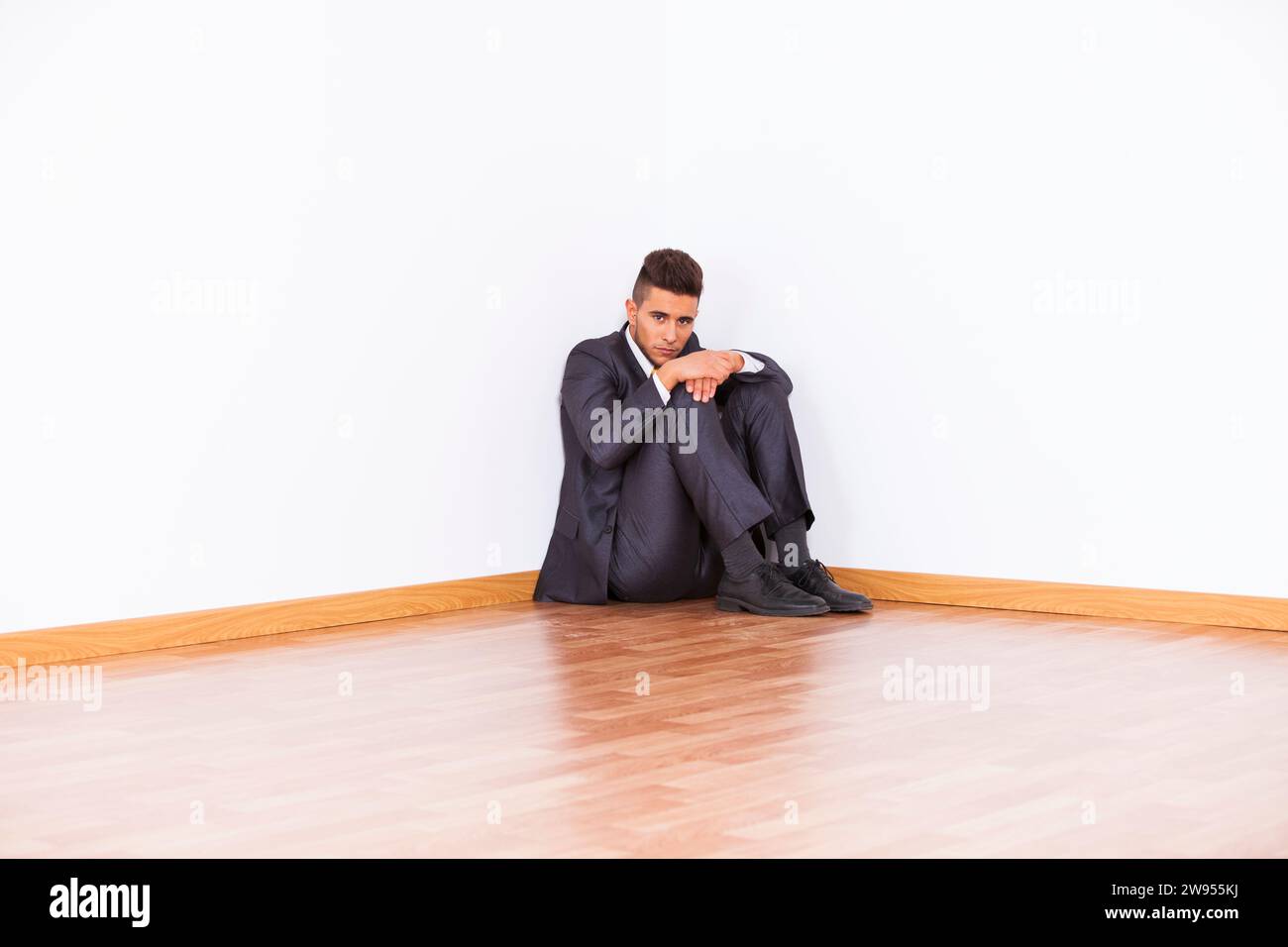 Businessman at the corner of his office room with fear Stock Photo