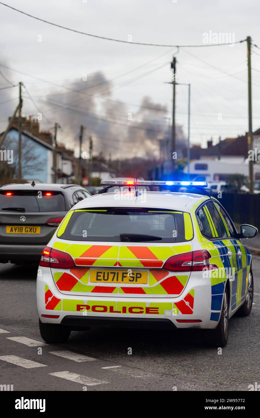 Stambridge, Essex, UK. 24th Dec, 2023. Around 60 firefighters are on scene at a large industrial unit fire on a farm in Stambridge, which is north of Southend on Sea in Essex. Police have closed roads in the area and are advising people living in the vicinity to close their windows due to the smoke. A number of businesses use storage units on the site for vehicles and other items which may have been lost in the fire Stock Photo