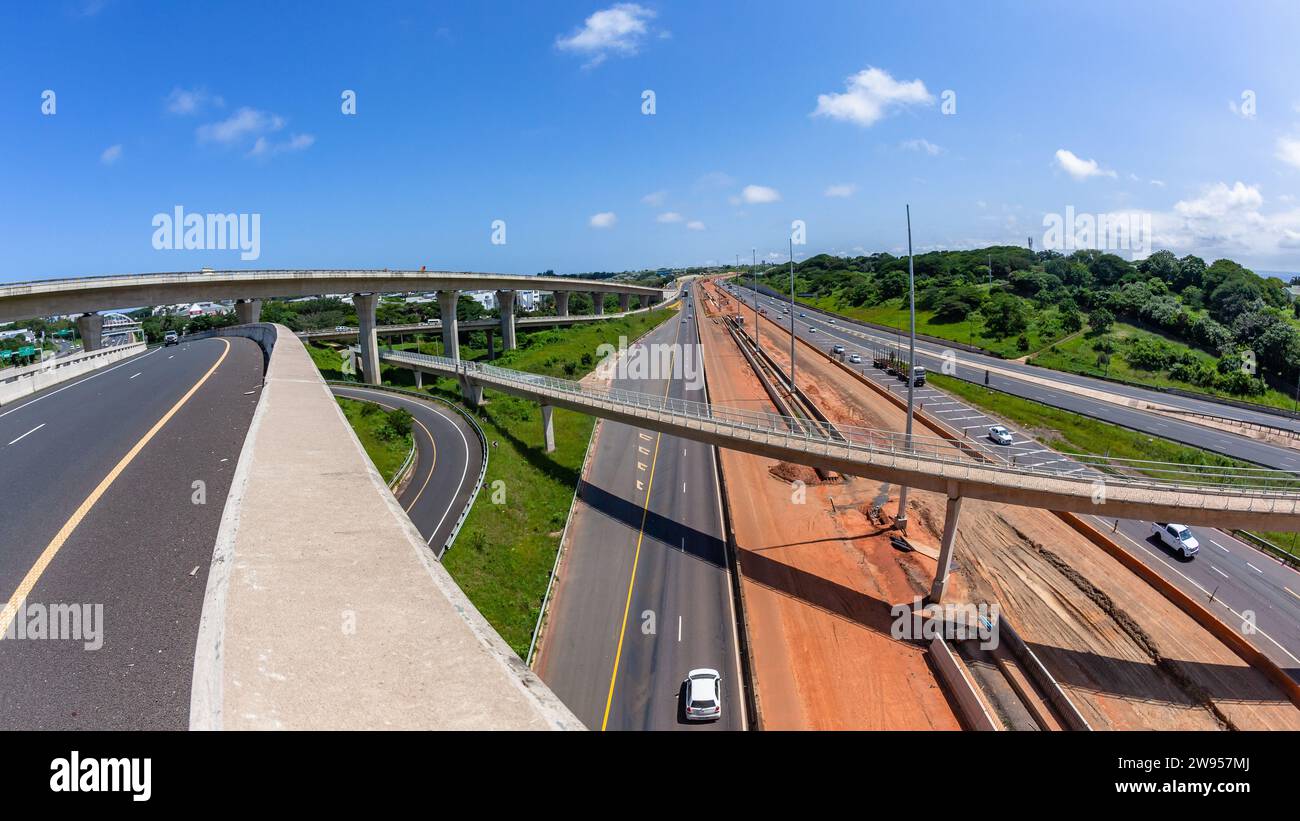 Driving road highway overhead ramps through construction expansion improvements with barriers, earthworks, new lanes for vehicle traffic flow landscap Stock Photo