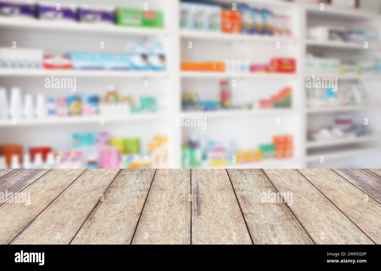 wood counter product display with blur shelves of drugs in the pharmacy ...