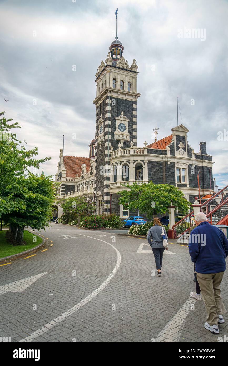 The the clock tower end of the Dunedin Railway Station with Anzac Square in the foreground Stock Photo