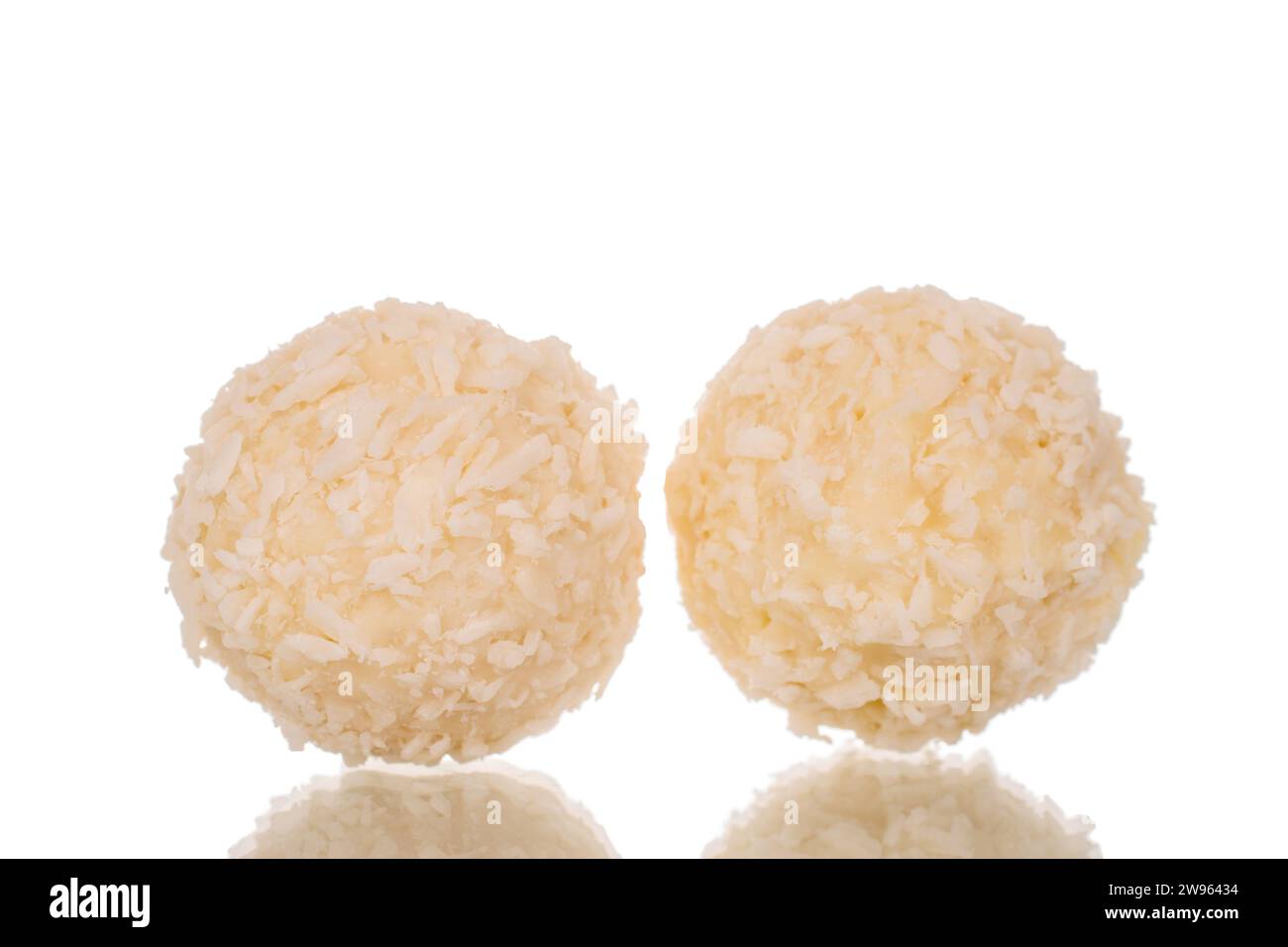 Two candies with nut and coconut flakes, macro, isolated on white