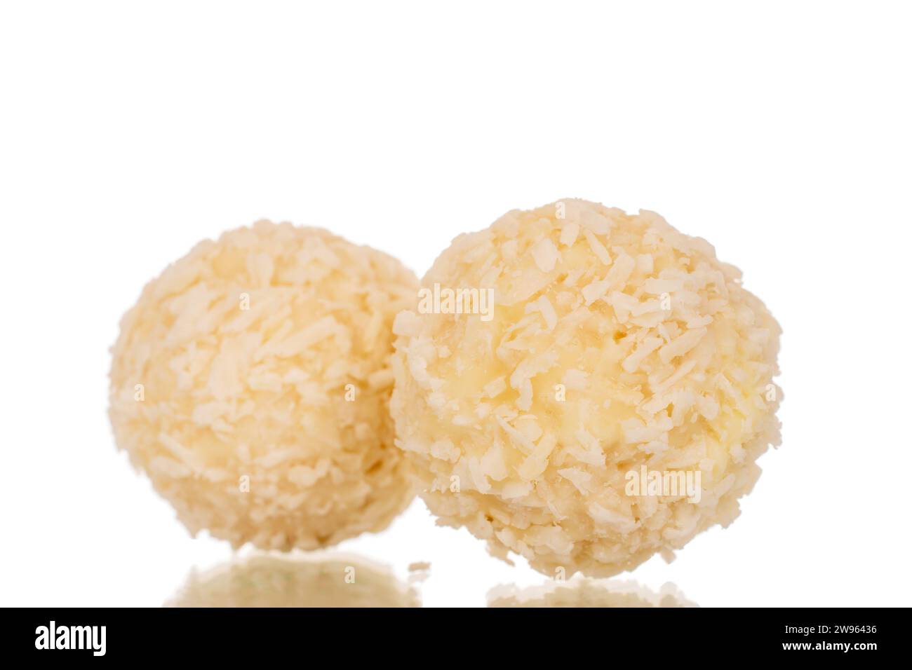 Two candies with nut and coconut flakes, macro, isolated on white