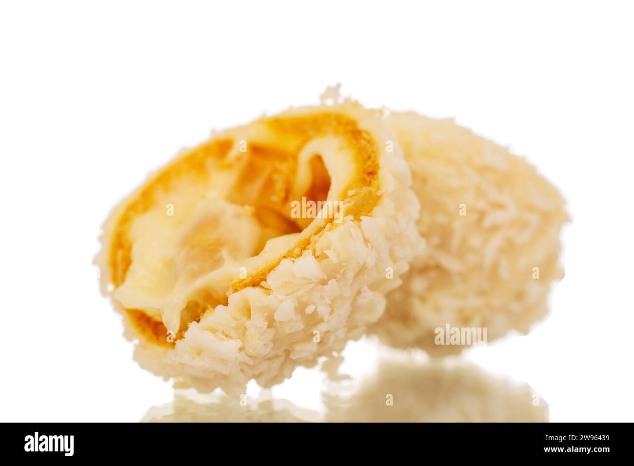 Two halves of candy with nut and coconut flakes, macro, isolated on