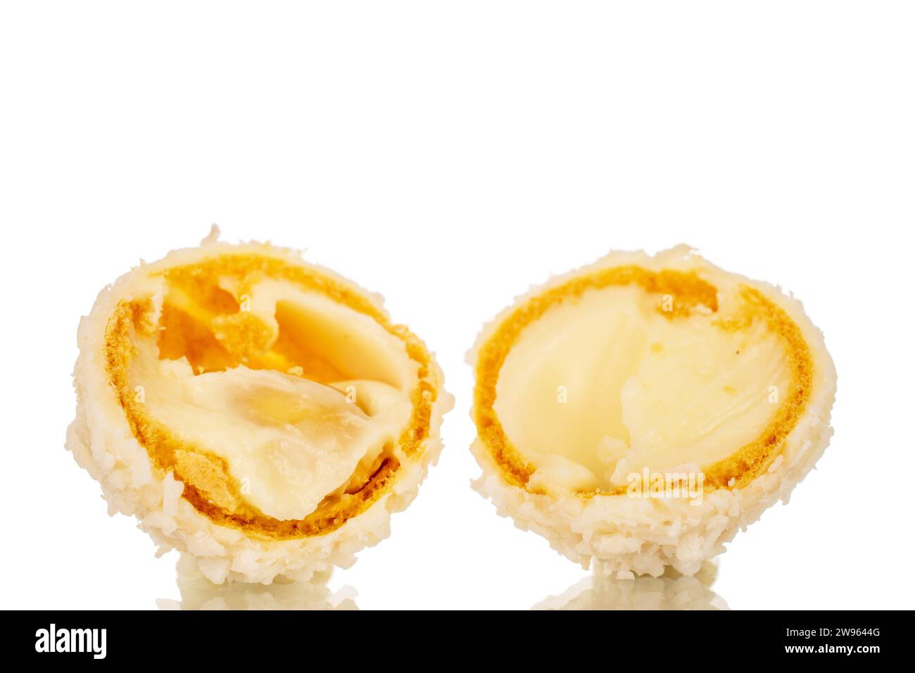 Two halves of candy with nut and coconut flakes, macro, isolated on