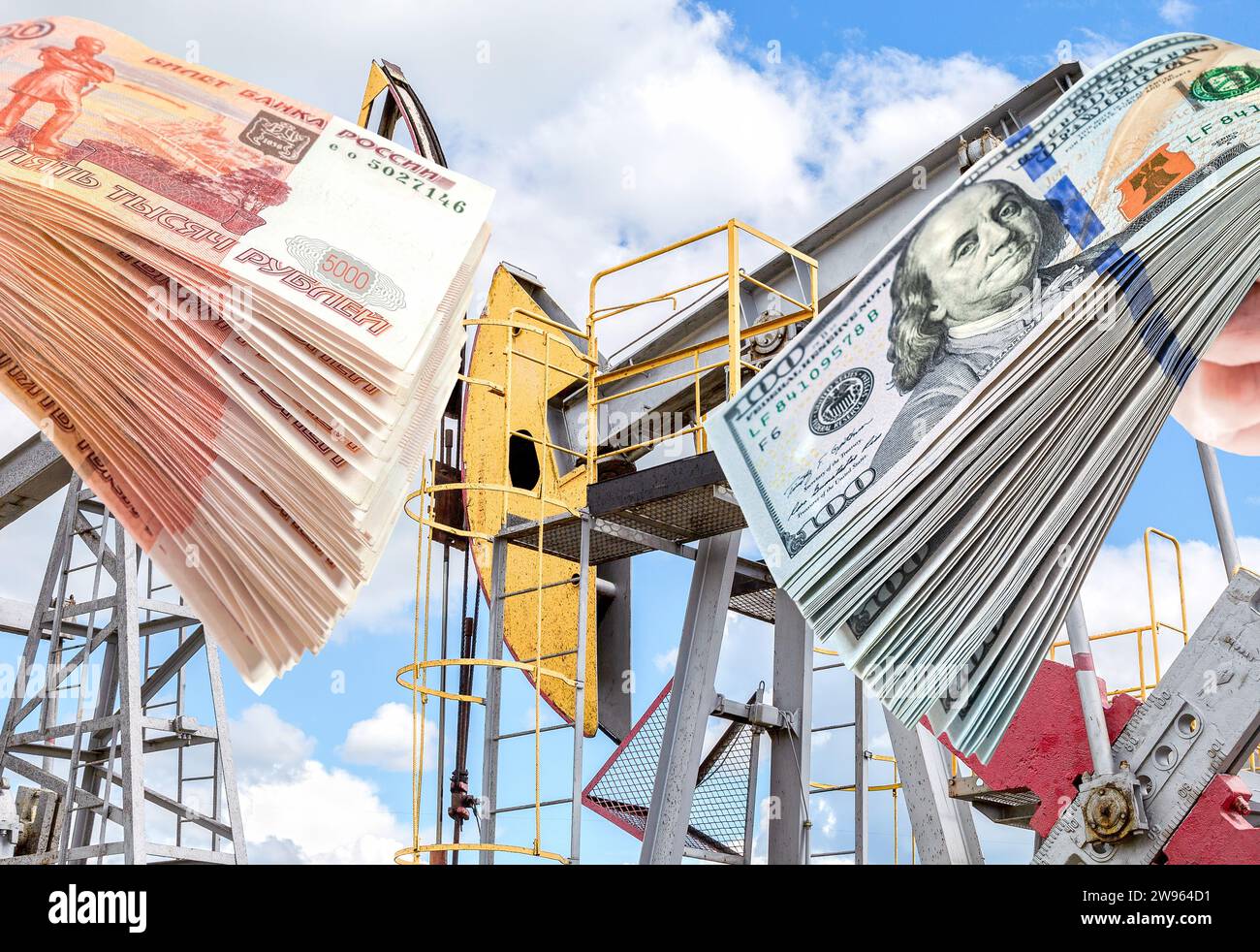American dollars and russian rubles in the hands against the oil pump jack extraction machine. Buying and selling oil for dollars. Oil industry equipm Stock Photo