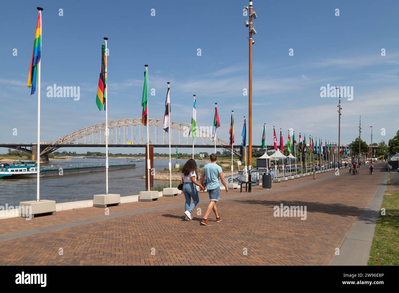 People walk on the quay along the river Waal in the city of Nijmegen. Stock Photo