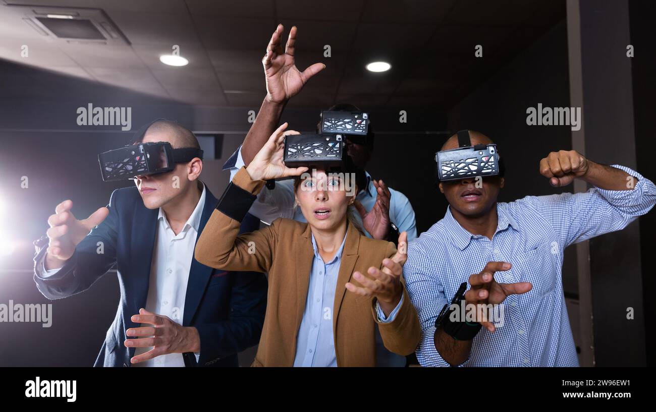Cheerful nice friends playing video games using virtual reality glasses Stock Photo