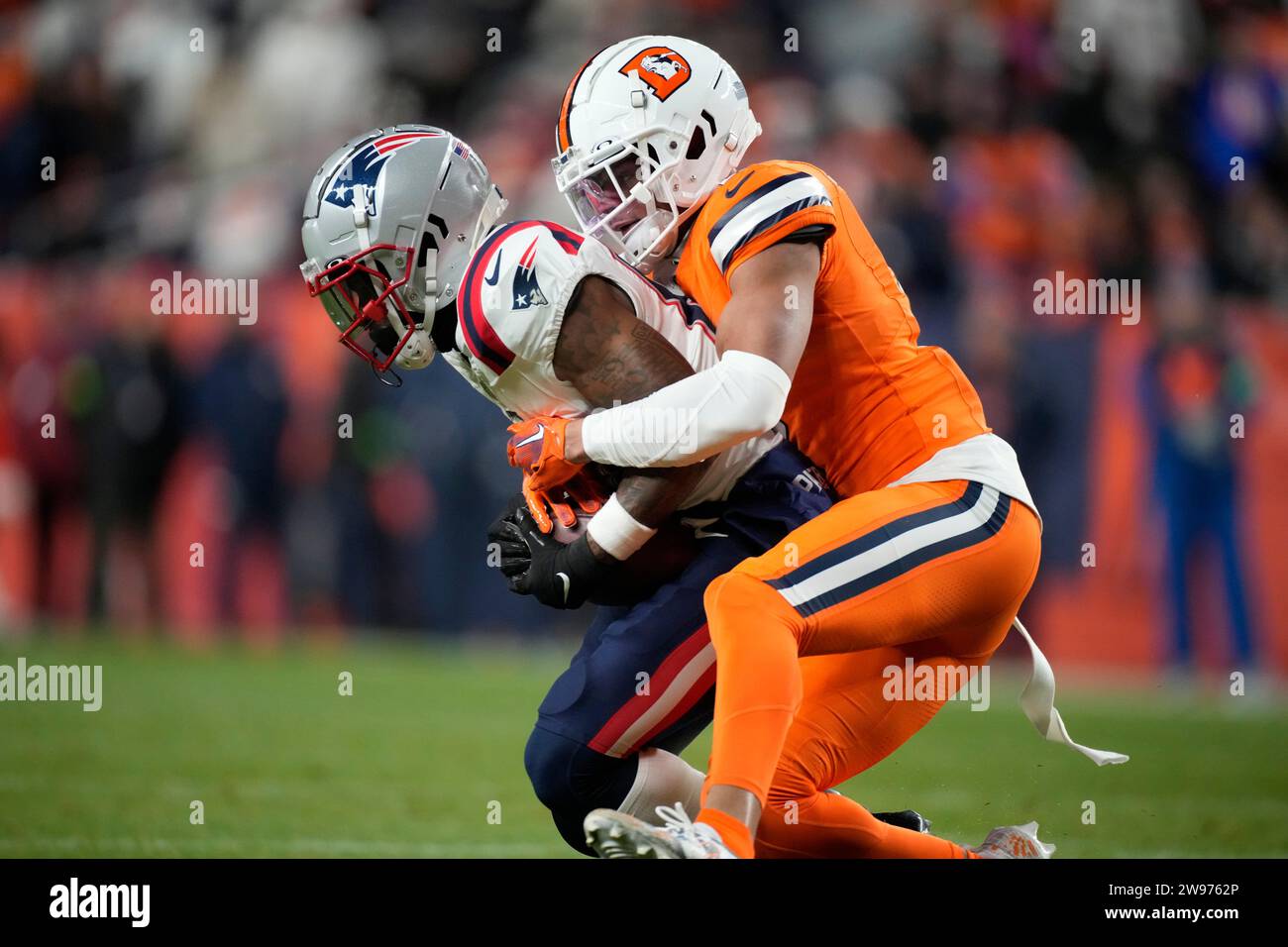 New England Patriots wide receiver Demario Douglas, left, is tackled b