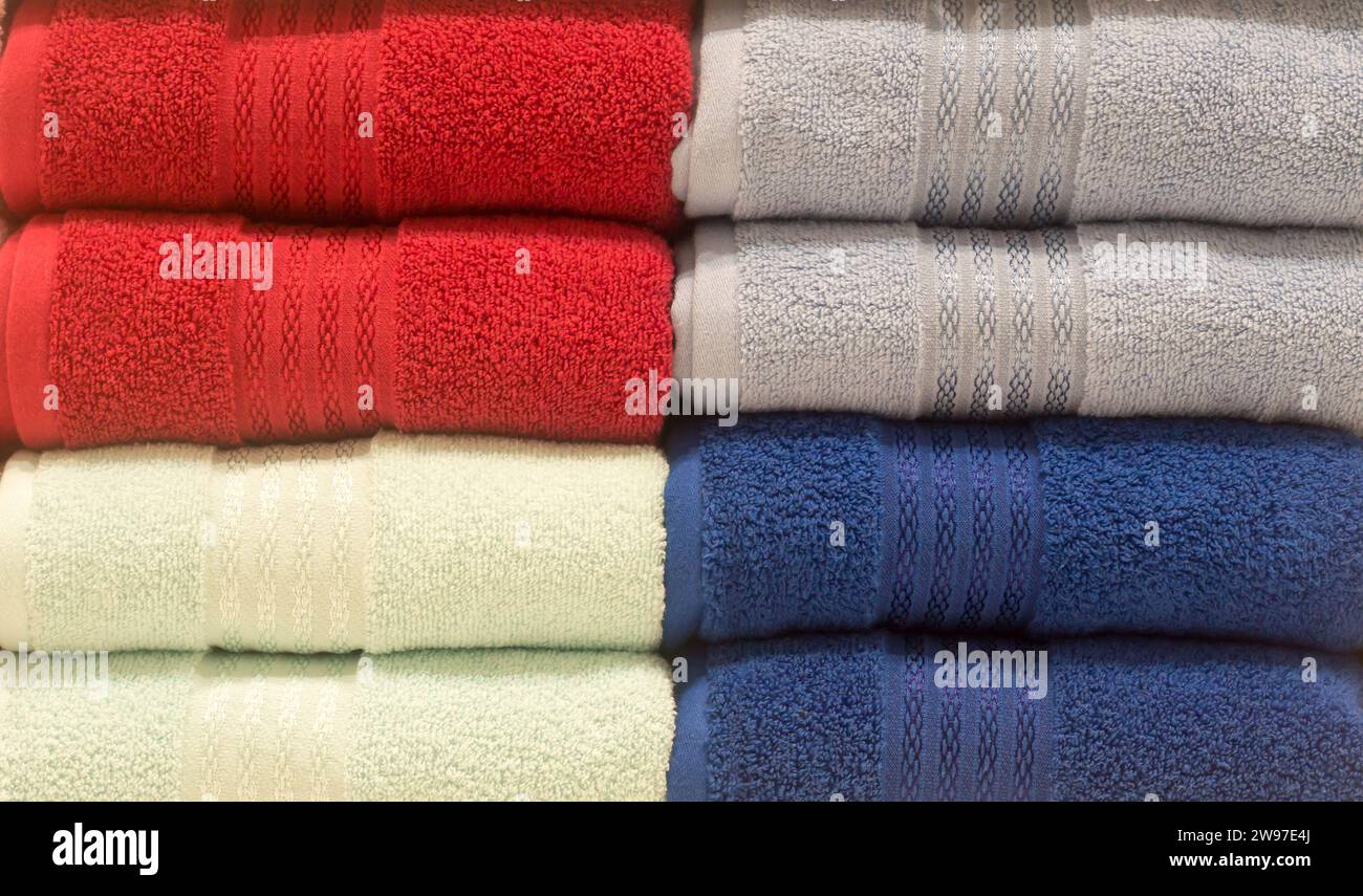Beautiful colorful bath towels are tidily folded on shelves in