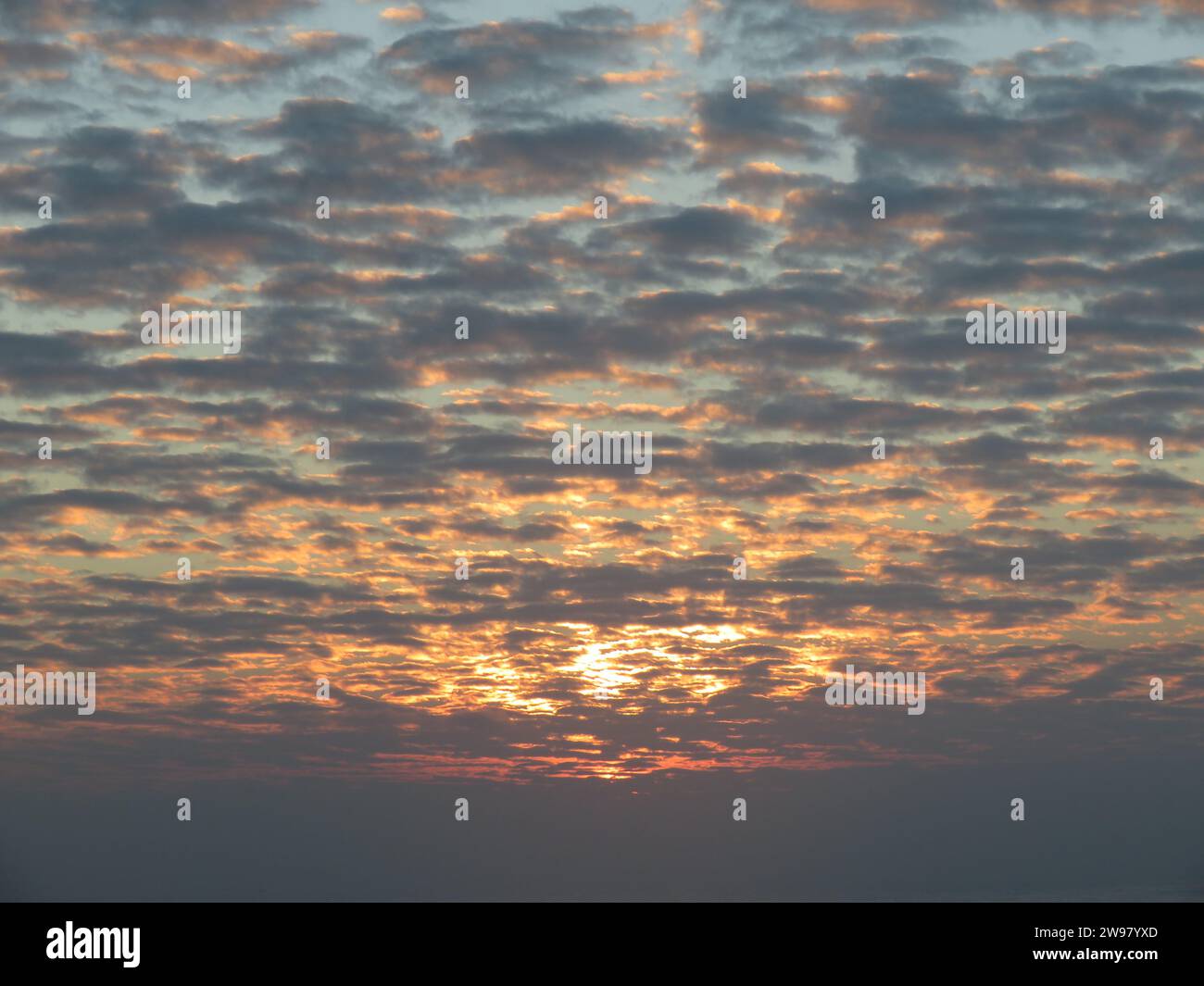 A stunning view of a picturesque shoreline, at sunset illuminating the tranquil waters below Stock Photo