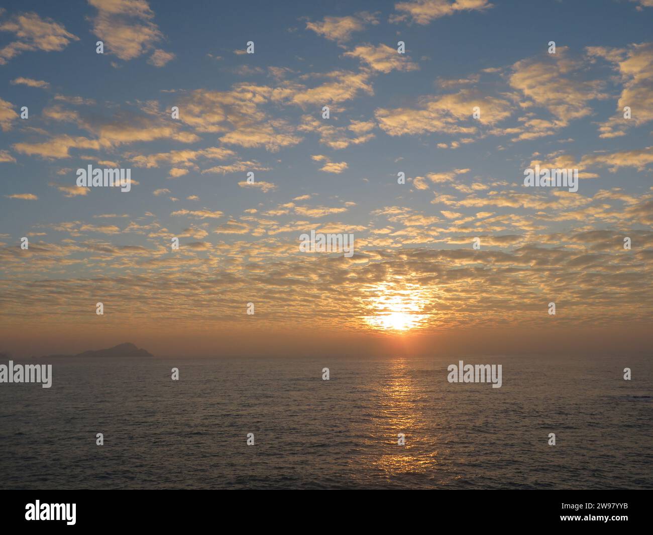 A stunning view of a picturesque shoreline, at sunset illuminating the tranquil waters below Stock Photo