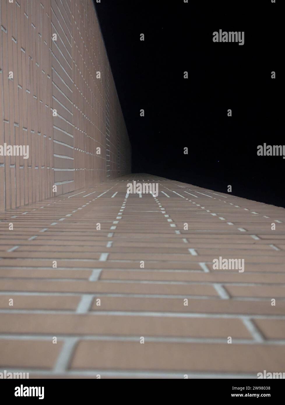 A tiled wall surface against a dark background Stock Photo
