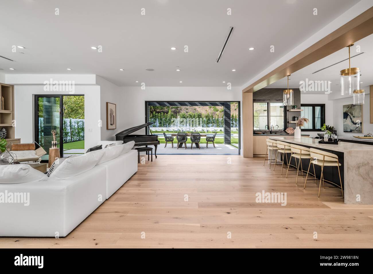 A contemporary open-plan kitchen and living room with large windows ...
