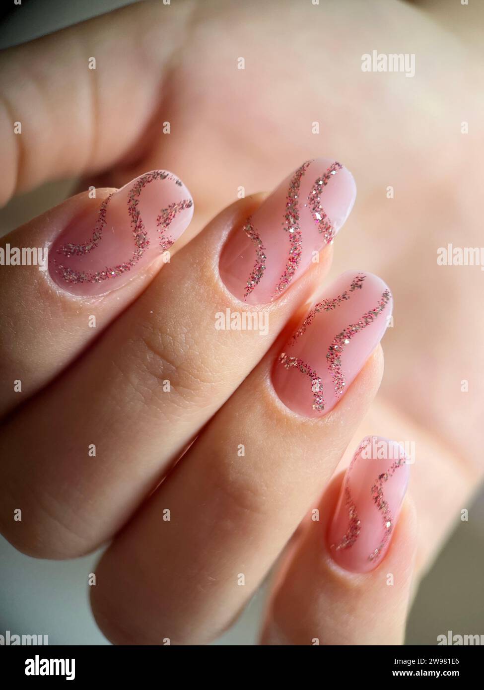 A female displaying a glamorous manicure with sparkling nails Stock Photo