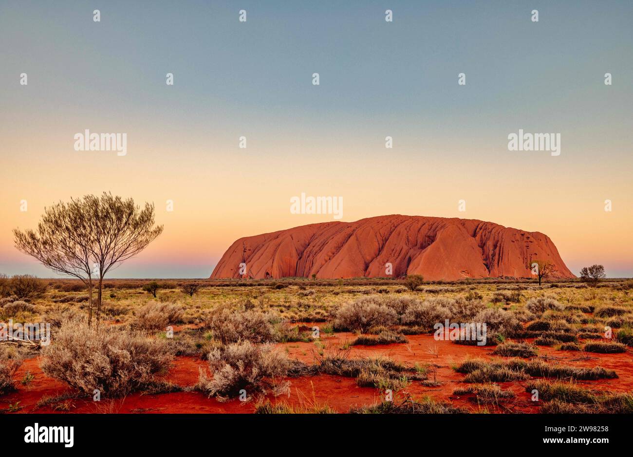 A scenic view of Uluru, a large sandstone formation in the center of Australia Stock Photo