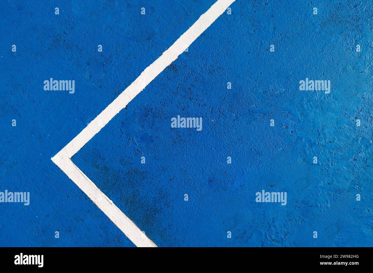 Blue textured court surface featuring a white boundary line forming an angle Stock Photo