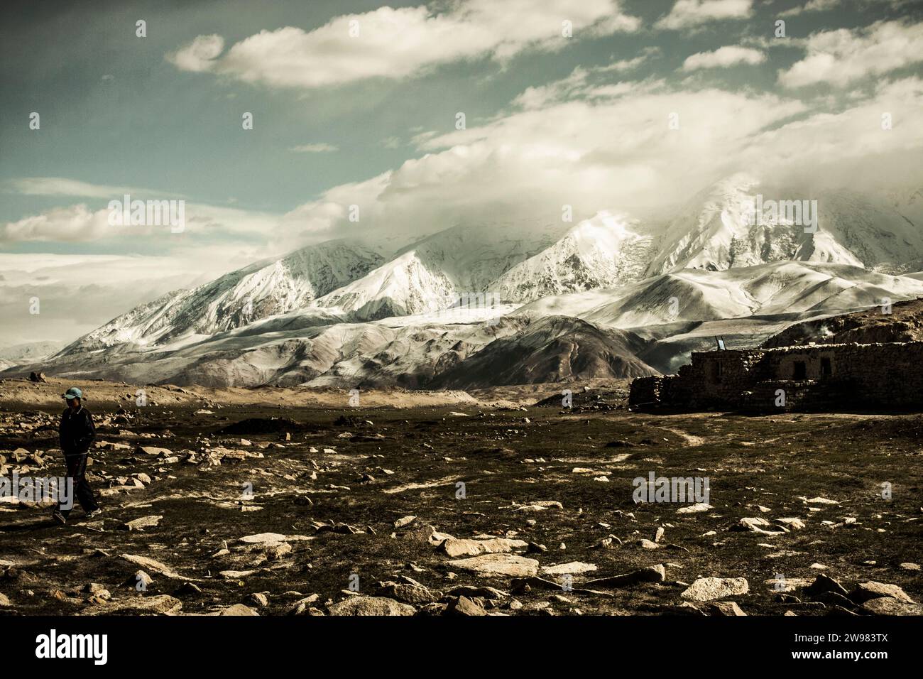Villagers walking away from their house. Stock Photo