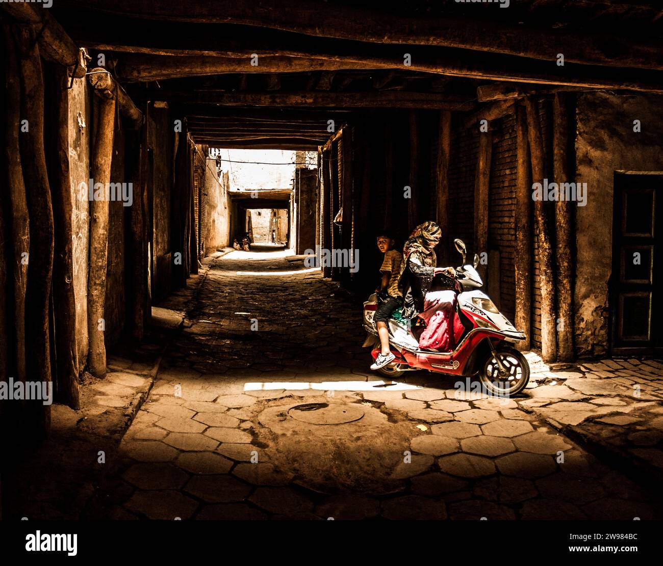An Uighur mother and her son returning home Stock Photo