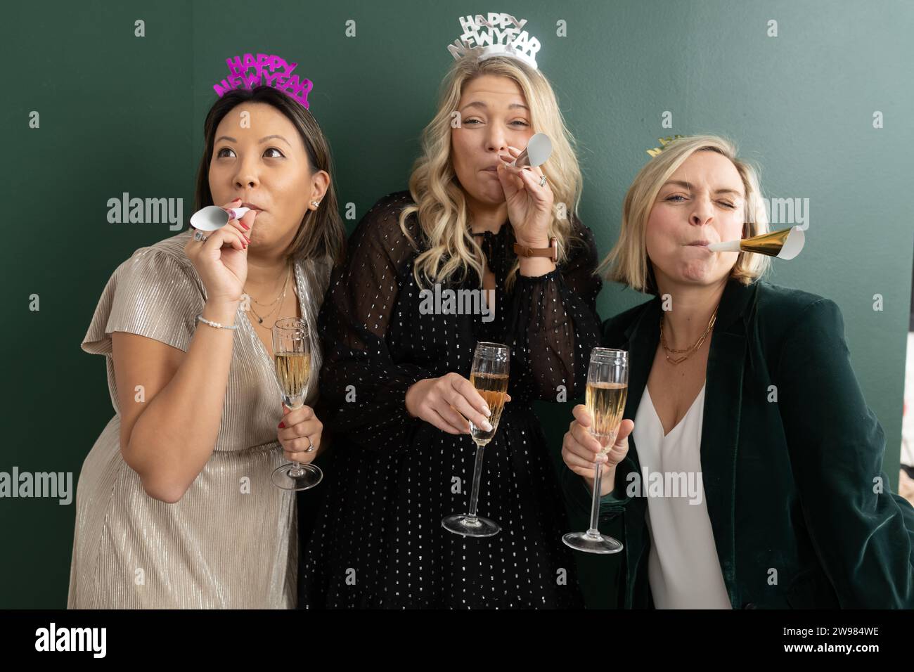 Women wearing party hats and noise makers on New Years Eve Stock Photo