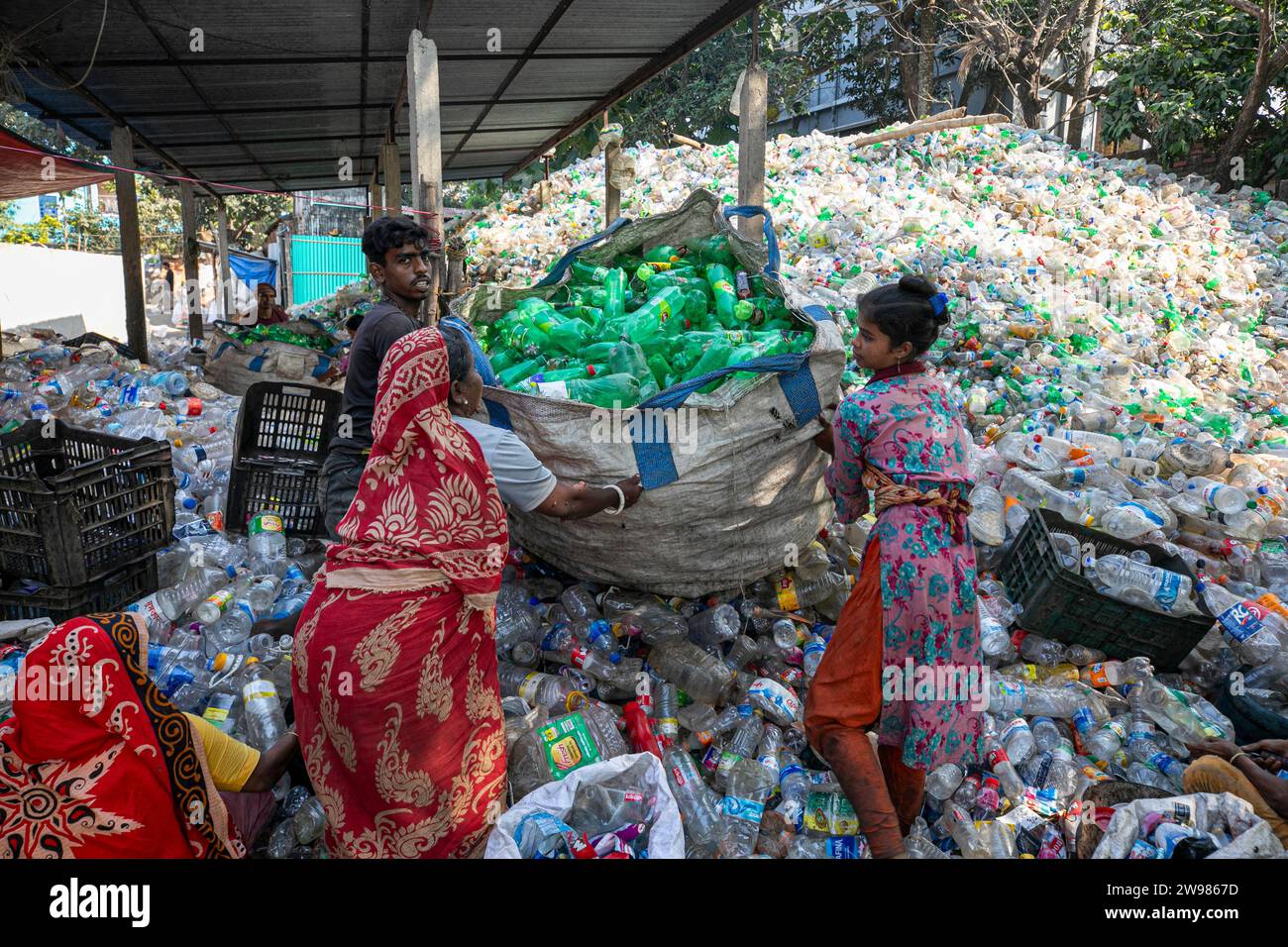 Workers sort used plastic bottles at a recycling factory. Recycle of