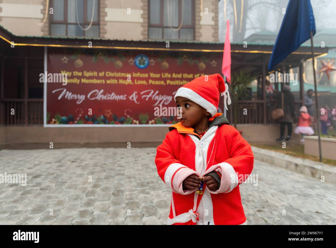 Srinagar, India. 25th Dec, 2023. A boy dressed as Santa looks on during