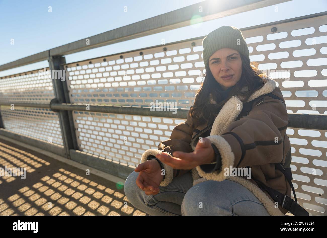 Depressed young woman and contemplating suicide, On the edge of a bridge with river below., Suicide and Major depressive disorder concept. Homeless fe Stock Photo