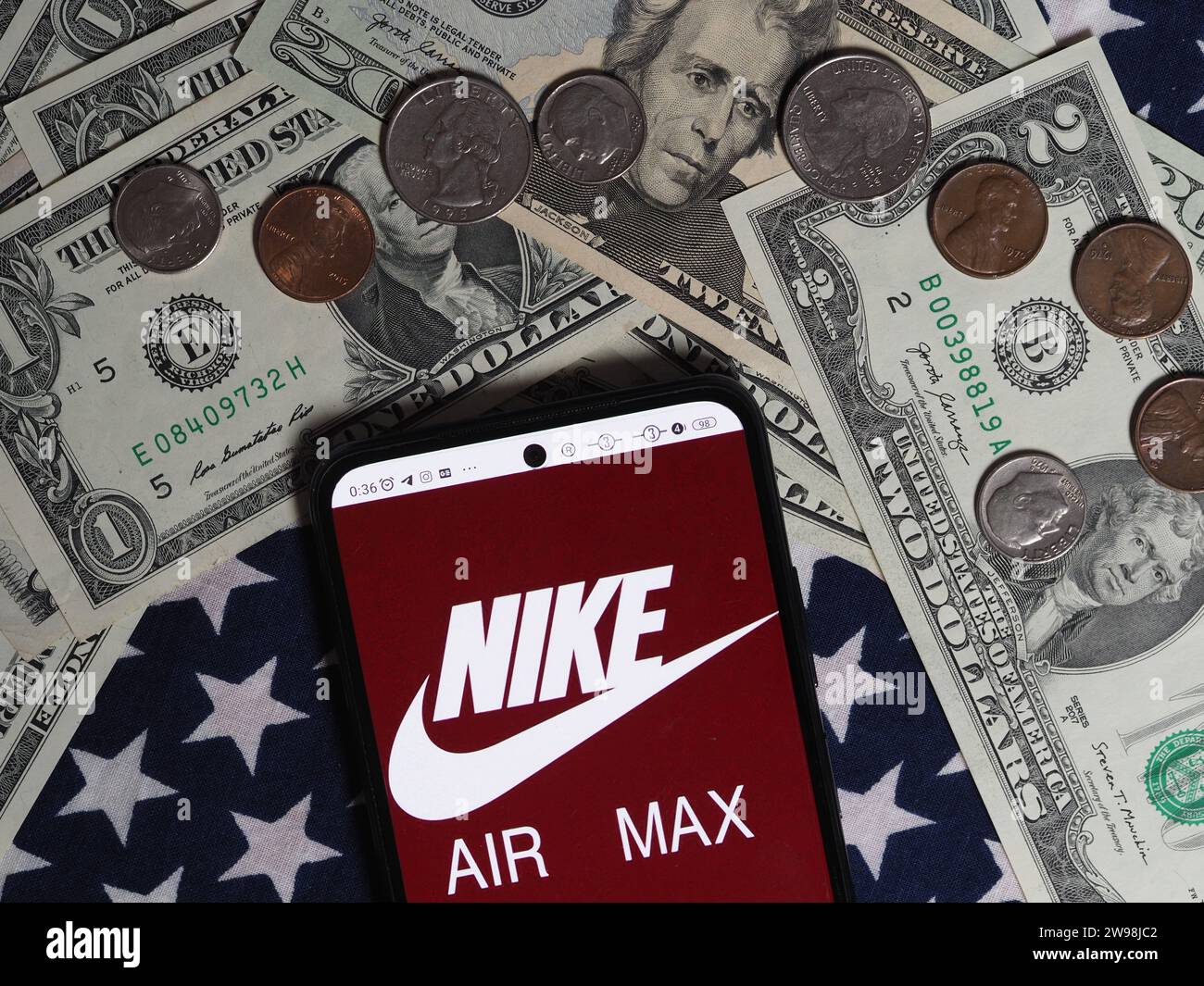 Bavaria, Germany - December 25. 2023: In this photo illustration, a Nike Air Max logo seen displayed on a smartphone with United States Dollar notes a Stock Photo
