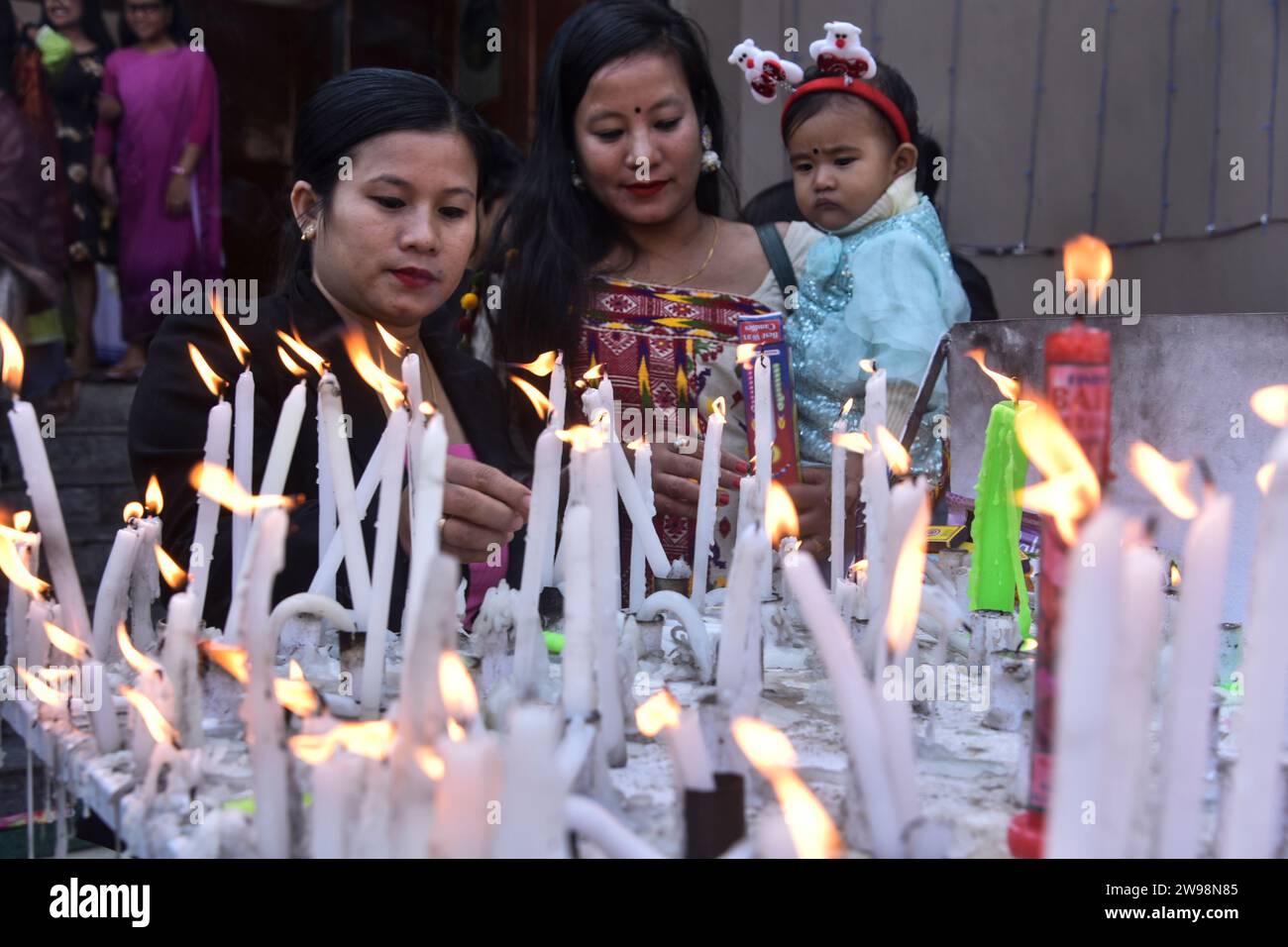 GUWAHATI,INDIA- DECEMBER 25: Devotees lighting the candle on the occasion of Christmas celebration, at Catholic Cathedral Dispur church in Guwahati, India on 25 December 2023. Stock Photo