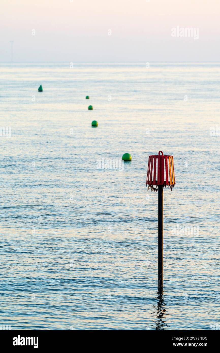 Three types of channel markers in a line off the coast of Herne Bay in