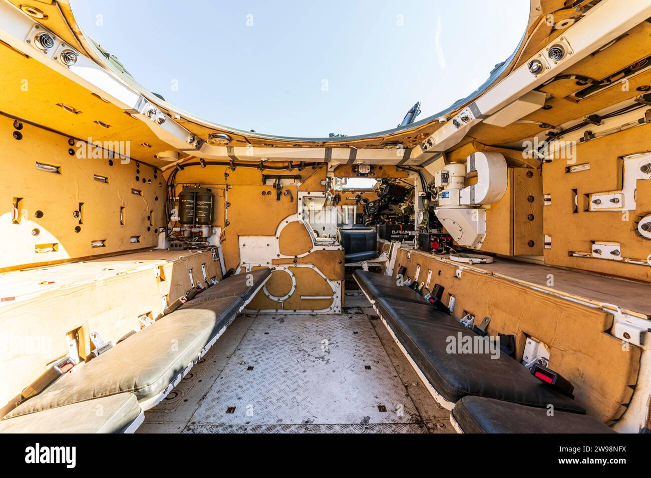 Interior of a decommissioned British FV432 armoured personal carrier, showing seating for the passengers. Open topped with blue sky. Stock Photo