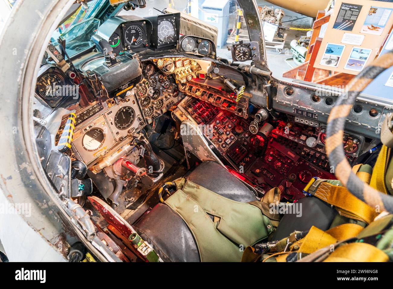 Interior of a 1960s RAF decommissioned Blackburn Buccaneer fighter bomber warplane cockpit showing various illuminated flight controls Stock Photo