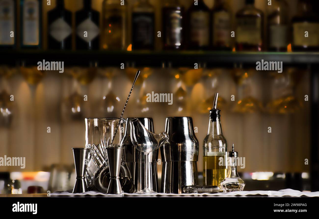Set of bar accessories for making cocktails, located on the bar, behind