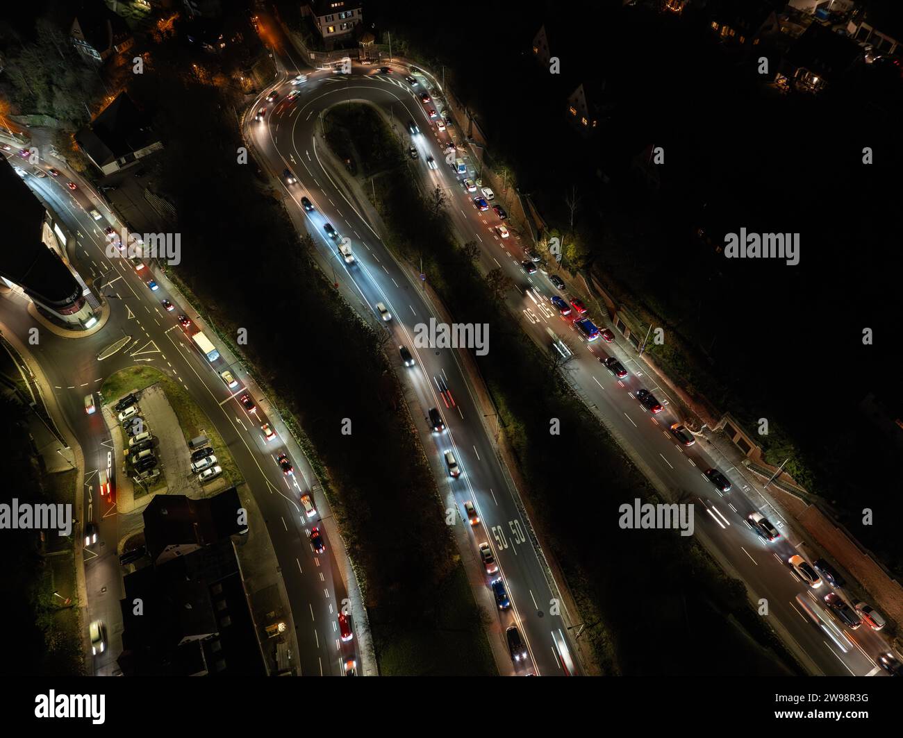 Nocturnal traffic scene with streaking lights of cars on a road bend, aerial view, traffic jam, traffic chaos, Calw. Black Forest, Germany Stock Photo