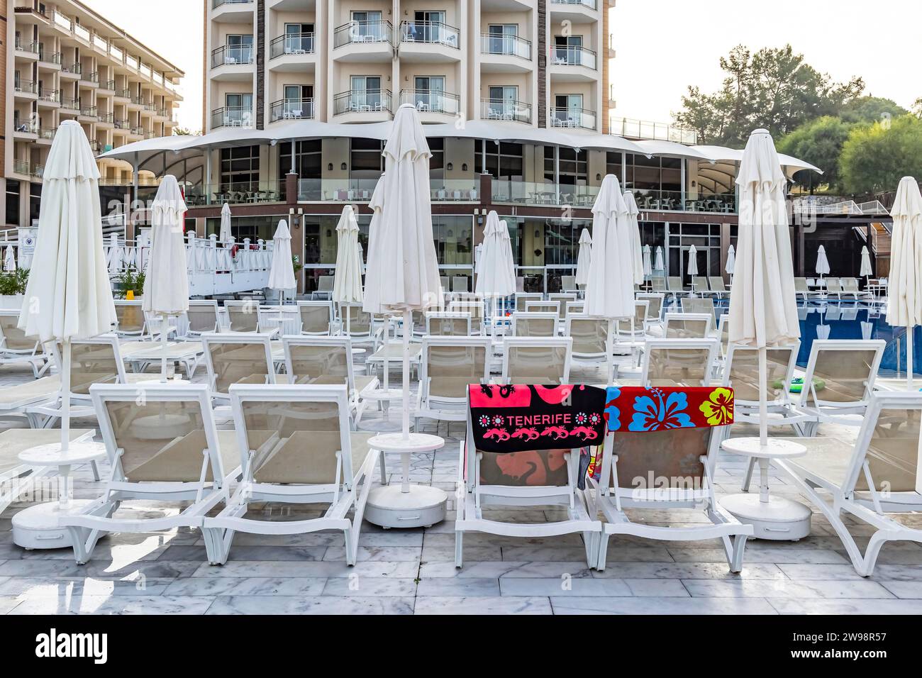 Reserved deckchairs, deserted hotel complex with swimming pool, towels lying on the deckchairs early in the morning, Kusadasi, Kusadasi, Aydin Stock Photo