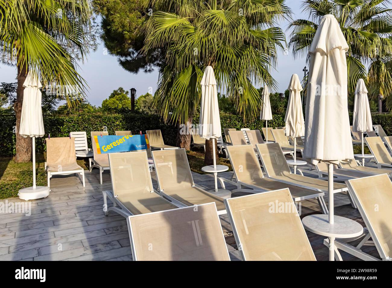 Reserved deckchairs, deserted hotel complex with swimming pool, towels lying on the deckchairs early in the morning, Kusadasi, Kusadasi, Aydin Stock Photo