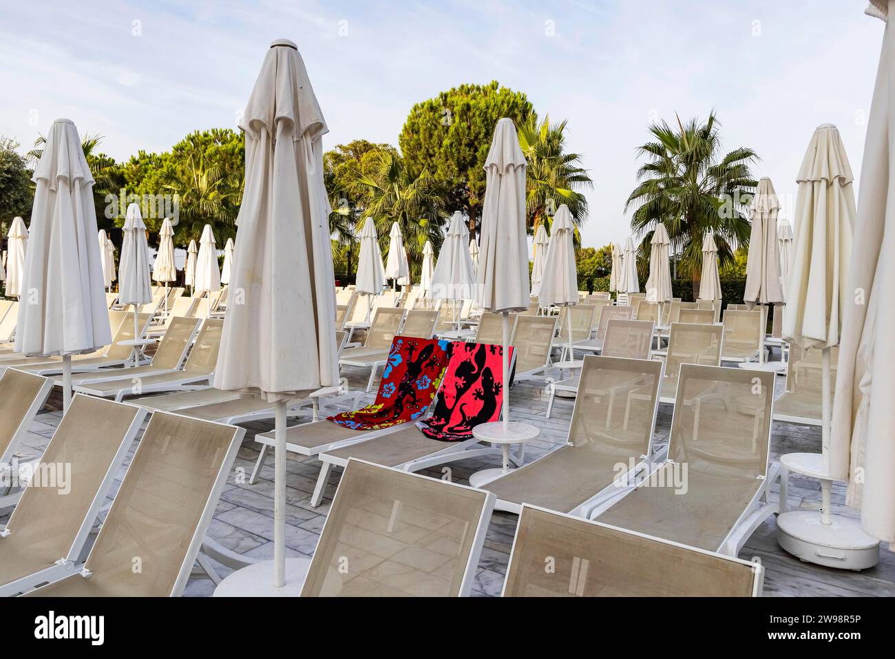 Reserved deckchairs, deserted hotel complex with swimming pool, towels lying on the deckchairs early in the morning, Kusadasi, Kusadasi, Aydin Stock Photo