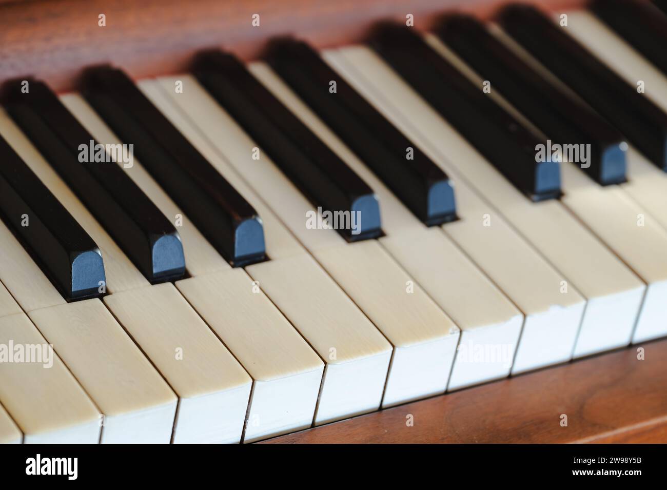 A closeup of the keys of an old vintage upright piano, worn out