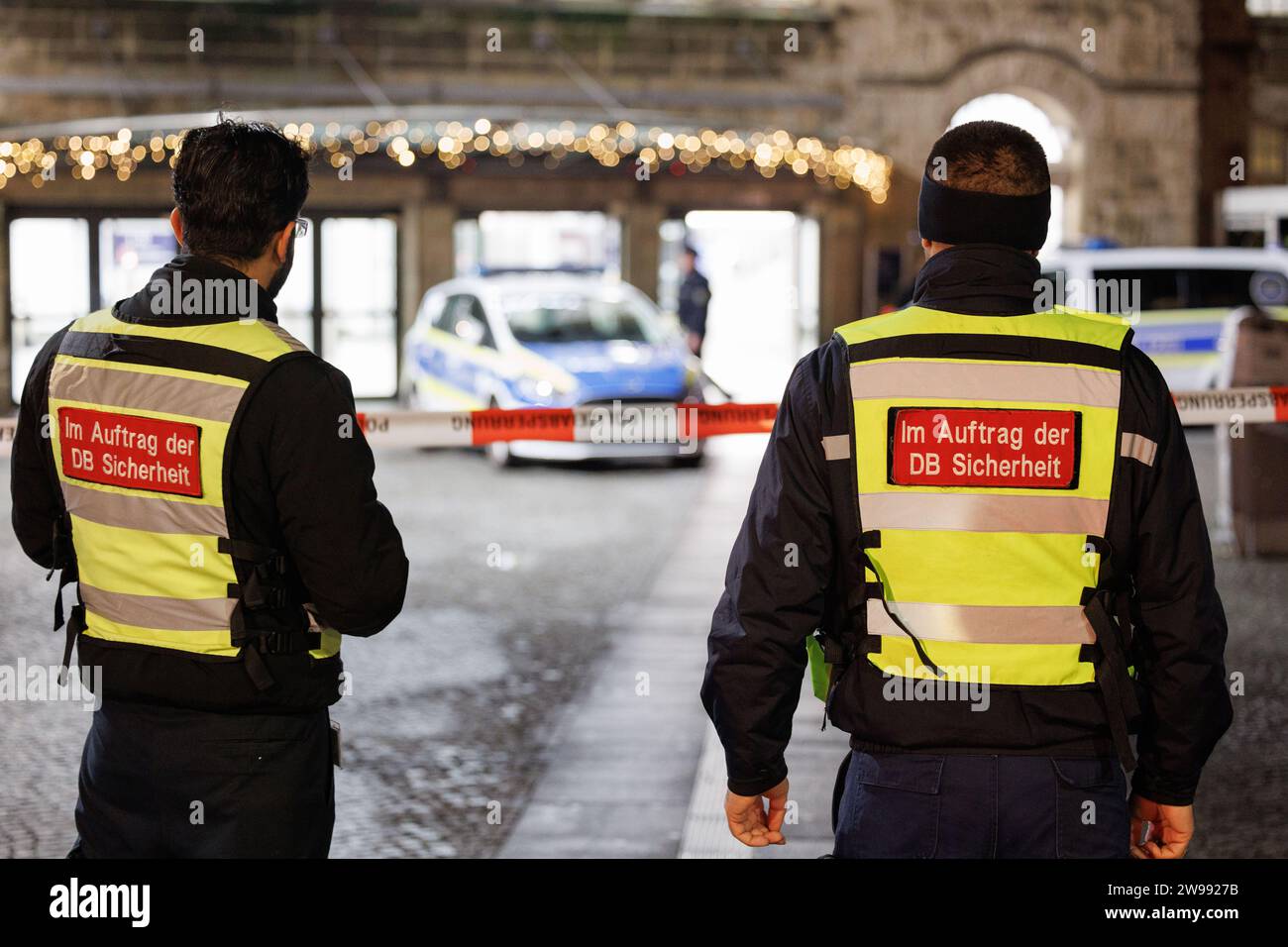 Bielefeld, Germany. 25th Dec, 2023. Railroad employees ('DB Sicherheit') can be seen in front of the main entrance to the station. The Bielefeld main station is searched by numerous officers. The reason for this is an anonymous attack threat. Credit: Friso Gentsch/dpa/Alamy Live News Stock Photo