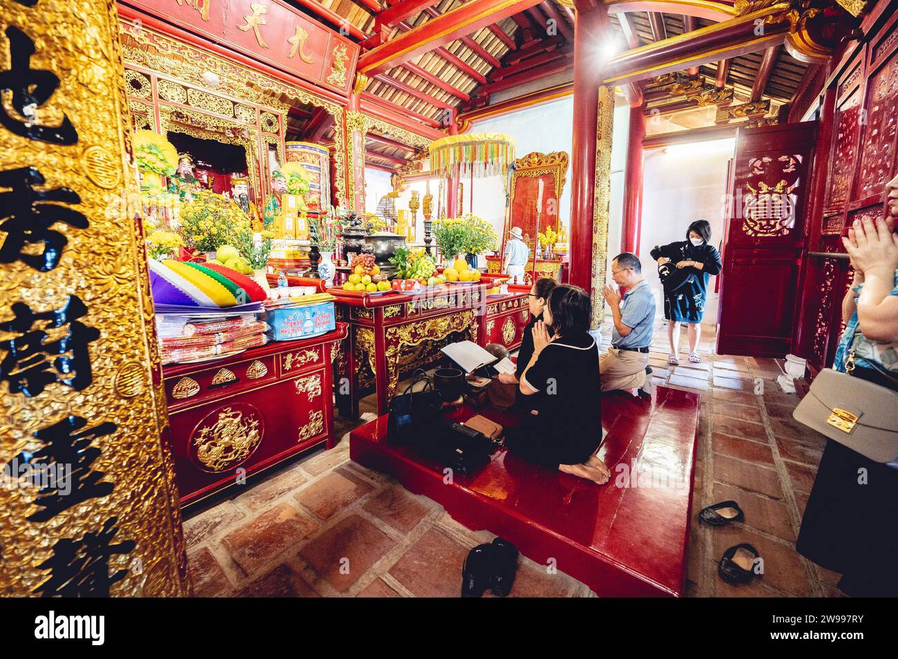 The Buddhist worshipers praying at the altars of Buddhist idols with