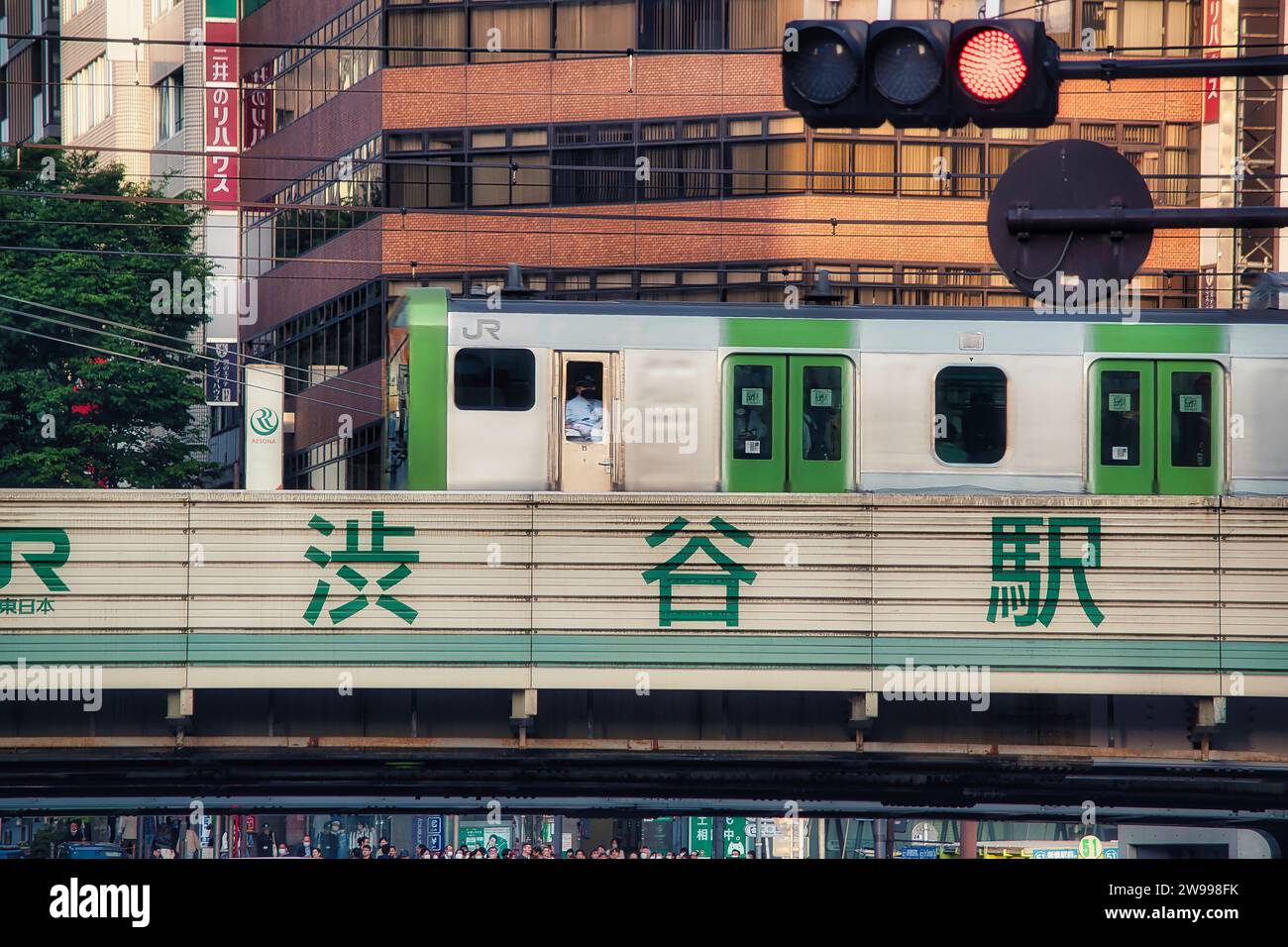 Photo of the back cabin of the famous Yamanote Line passing on the Shibuya Station bridge just before entering the Shibuya Station. Stock Photo