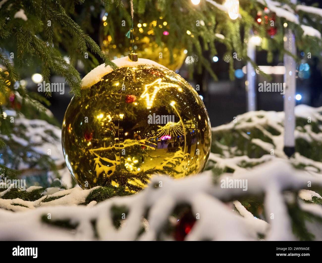 A golden Christmas ornament hanging from a tree branch Stock Photo - Alamy