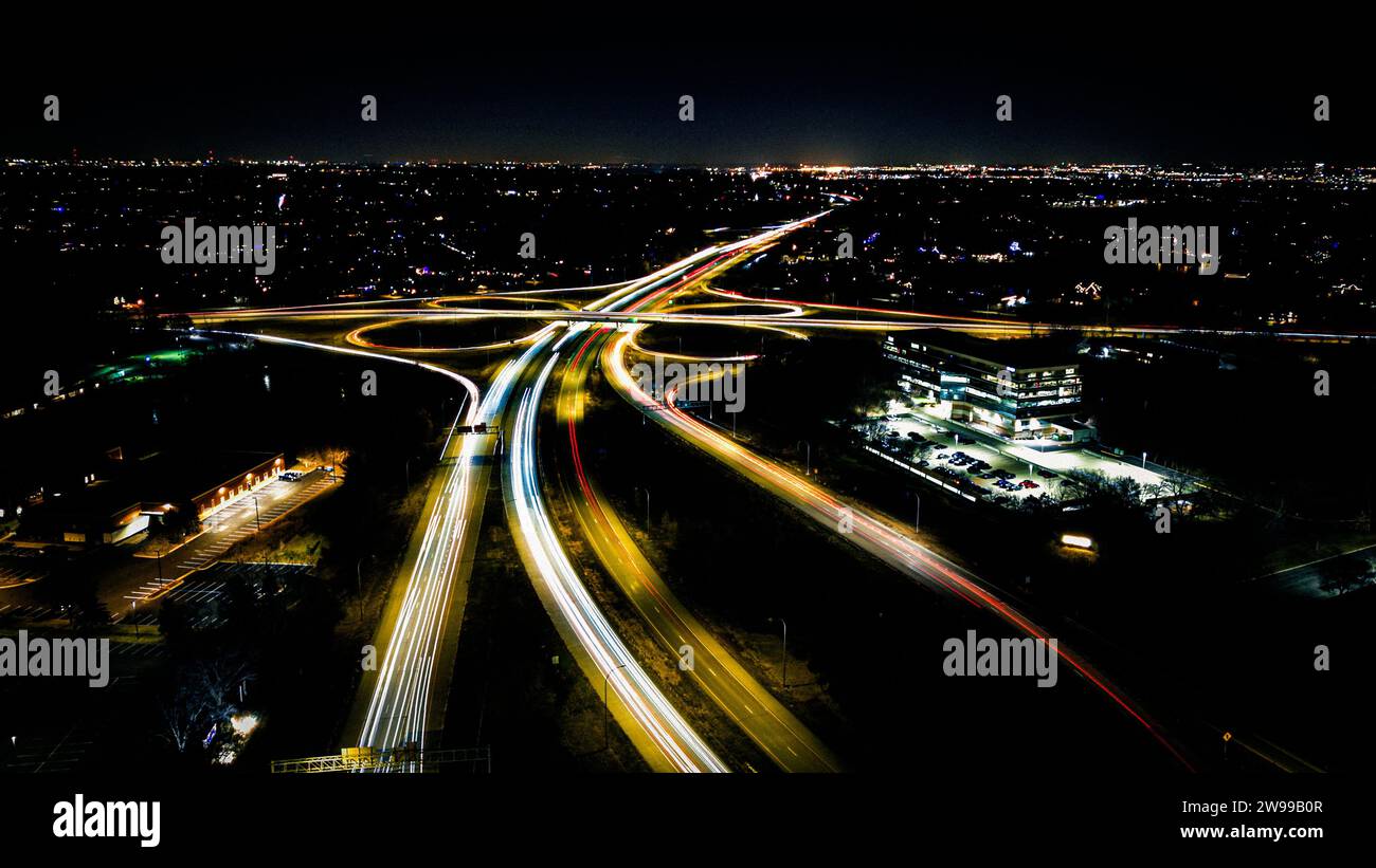 This time lapse image shows busy city traffic in the evening, with a variety of cars traveling on the road Stock Photo