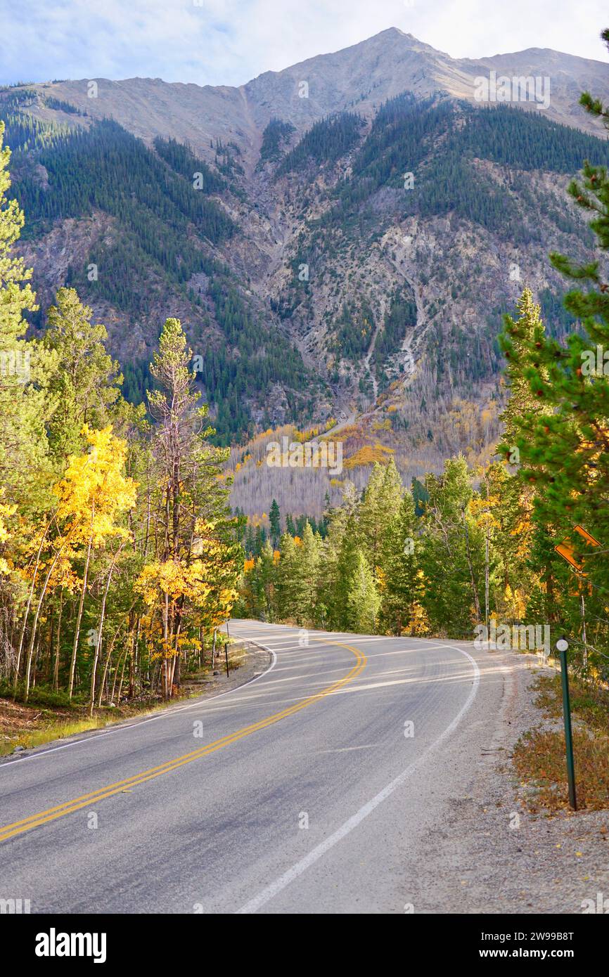 A vertical of a winding highway surrounded by mountain ranges and ...