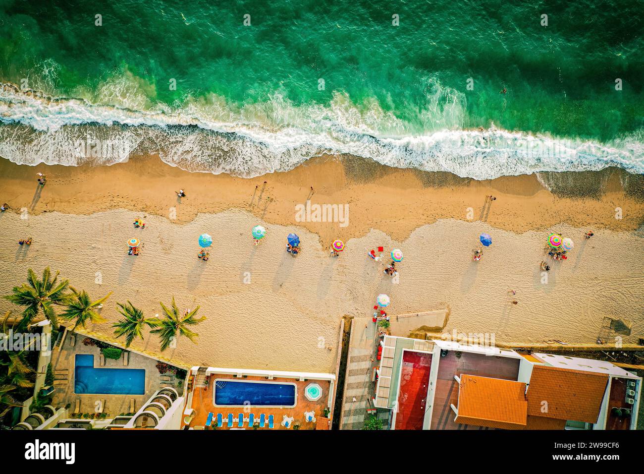 Aerial top down shot of the beach and colorful ocean with umbrellas Stock Photo